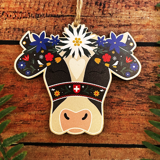 Decorative cow ornament with floral design on a wooden background