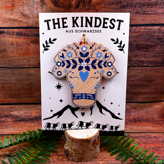 Modern Swiss alpine cow illustration on wooden decoration presented on backing as switzerland souvenir