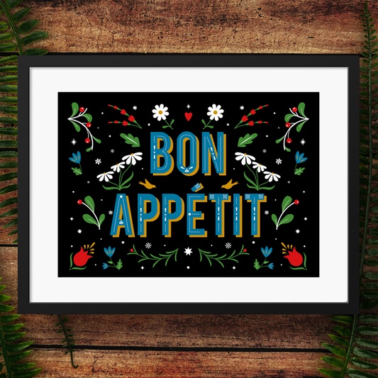 Framed artwork with 'Bon Appetit' text and floral decorations on a wooden background