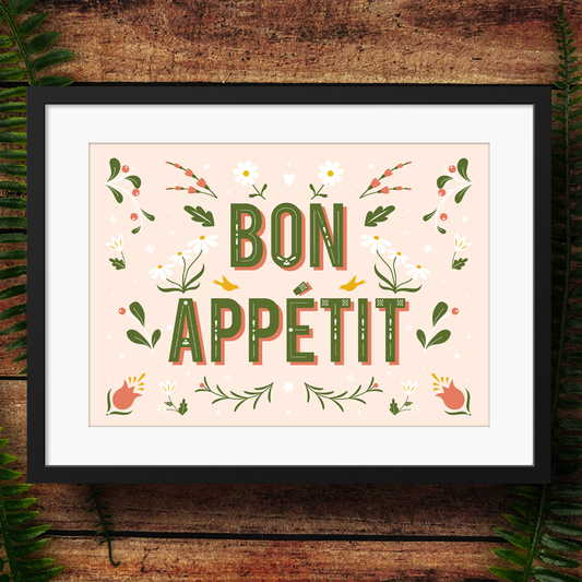 Framed artwork with 'Bon Appetit' text on a wooden background