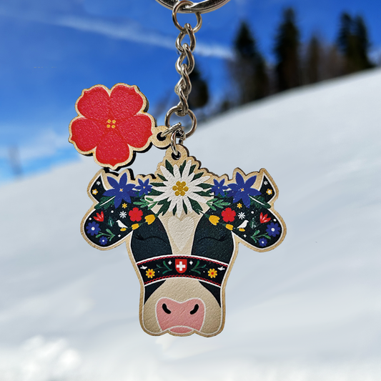 Keychain with cow design and floral patterns on a snowy background