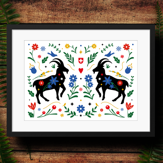 Framed artwork with black ibex silhouettes and colorful flowers on a white background, displayed on a wooden surface.