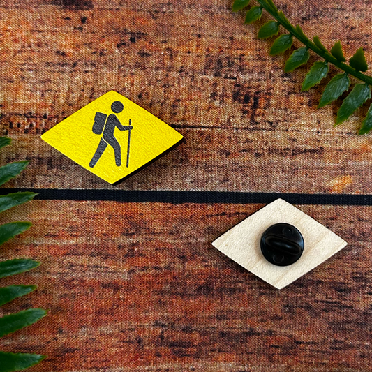 famous swiss wanderweg hiking trail signs on souvenir wooden pin badge