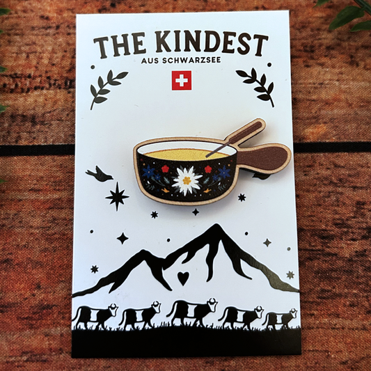 edelweiss adorned fondue pot wooden pin badge presented on backing card