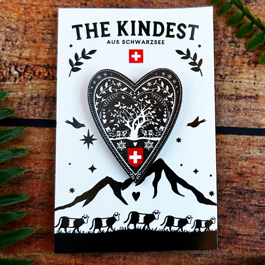 swiss papercut, decoupage, scherenschnitte design on wooden pin badge presented on backing card swizerland souvenir 