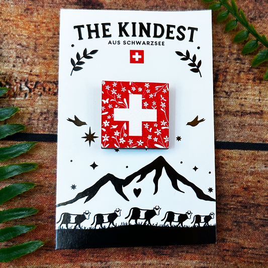 floral swiss flag wooden pin badge presented on backing card, souvenir of switzerland