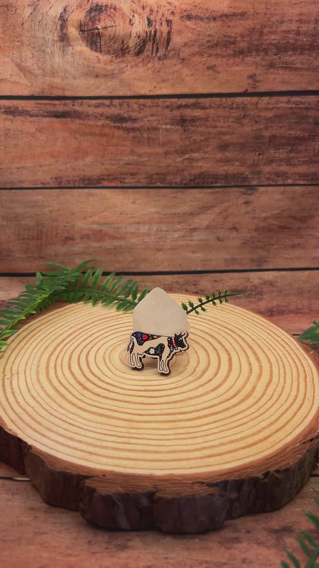 video of swiss cow wooden pin badge with alpine flora.