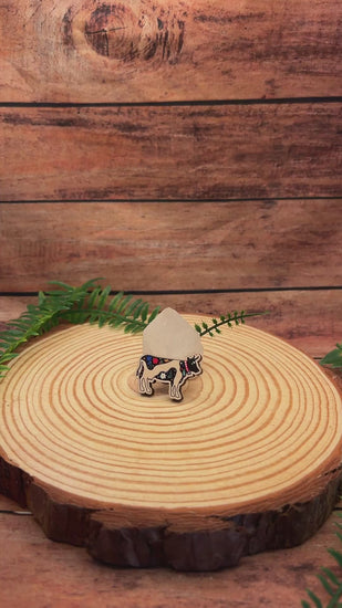 video of swiss cow wooden pin badge with alpine flora.