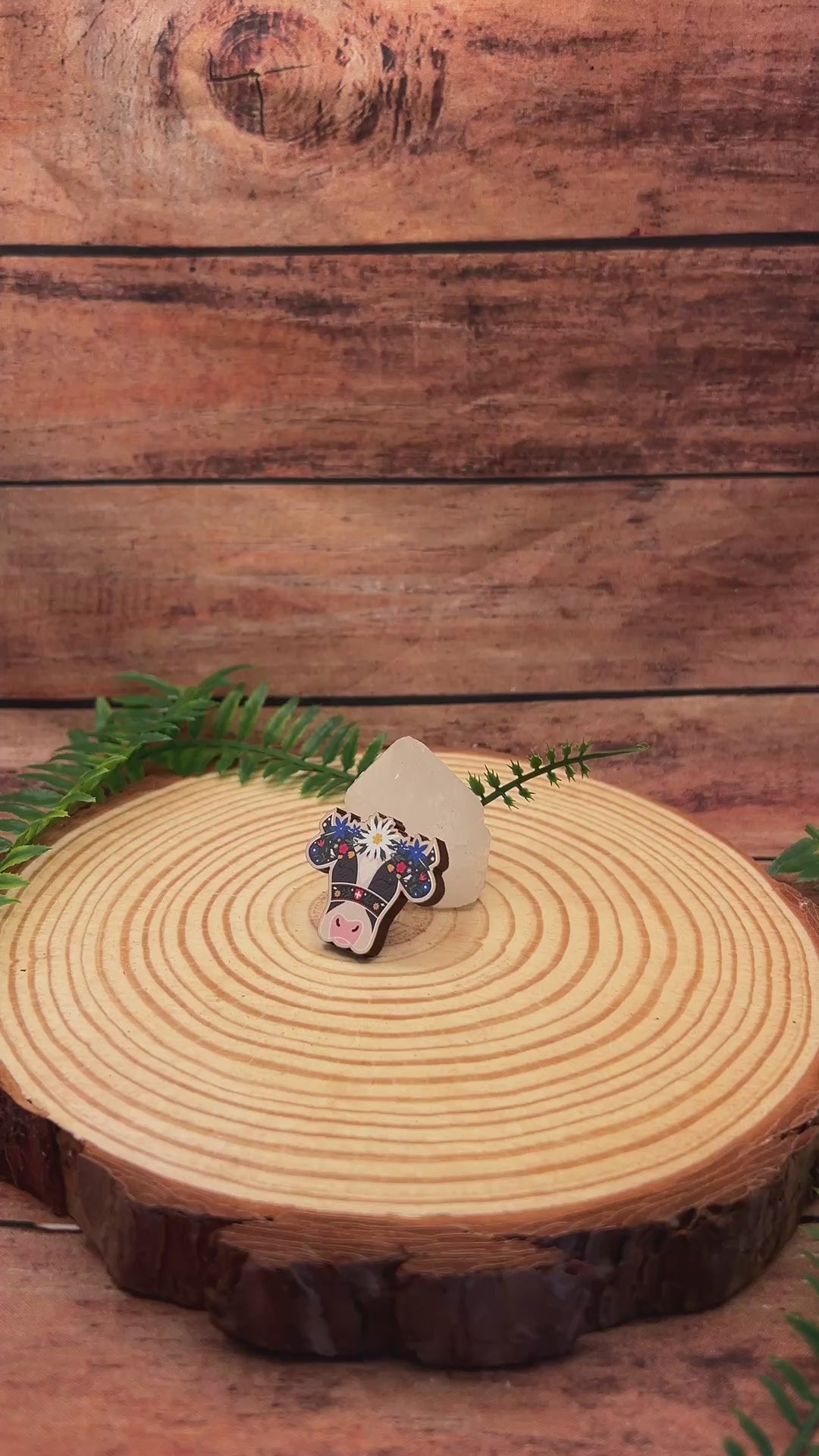 video showing wooden pin badge of a holstein cow with flowers on its head in the swiss alpabzug style.