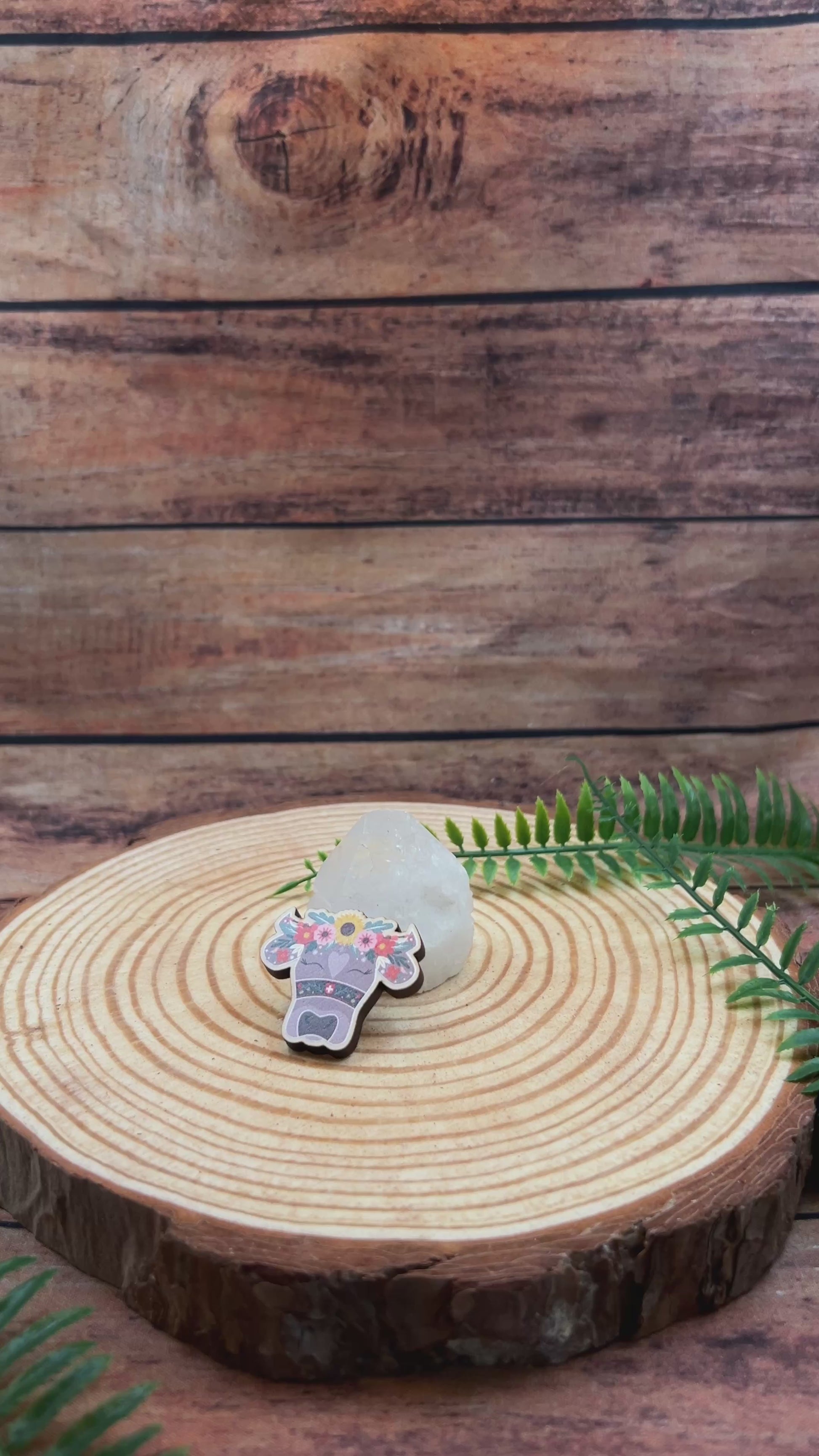 video showing illustrated swiss cow with flowers on wooden pin badge