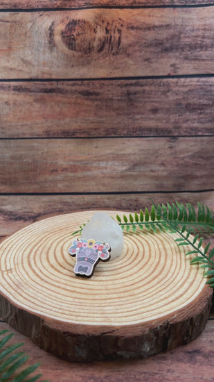 video showing illustrated swiss cow with flowers on wooden pin badge